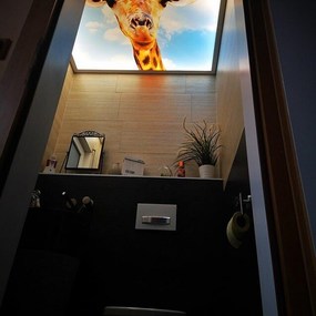 Eine Giraffe auf einer Deckenleuchte blickt in ein modern eingerichtetes Badezimmer.