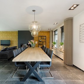 Moderner Essbereich mit Holztisch, schwarzen Stühlen und stilvoller Dekoration.